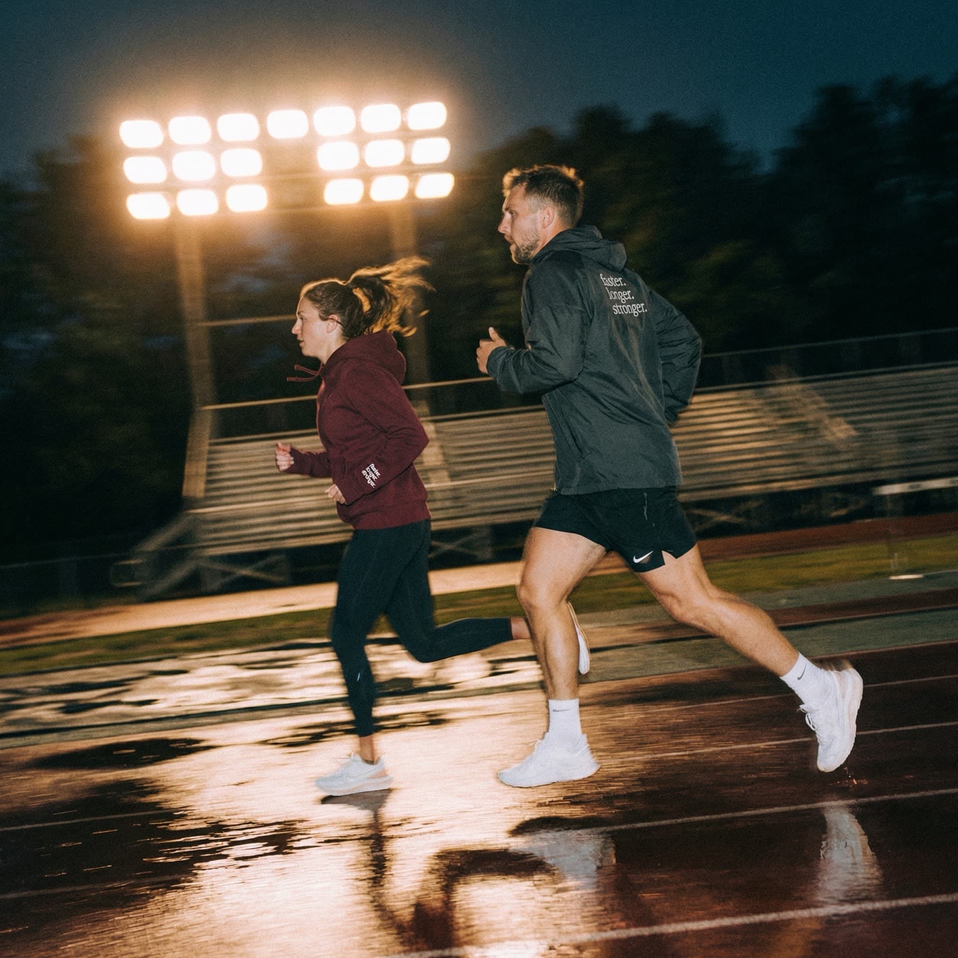 Everyday athletes training on a track at night, running and strength combined
